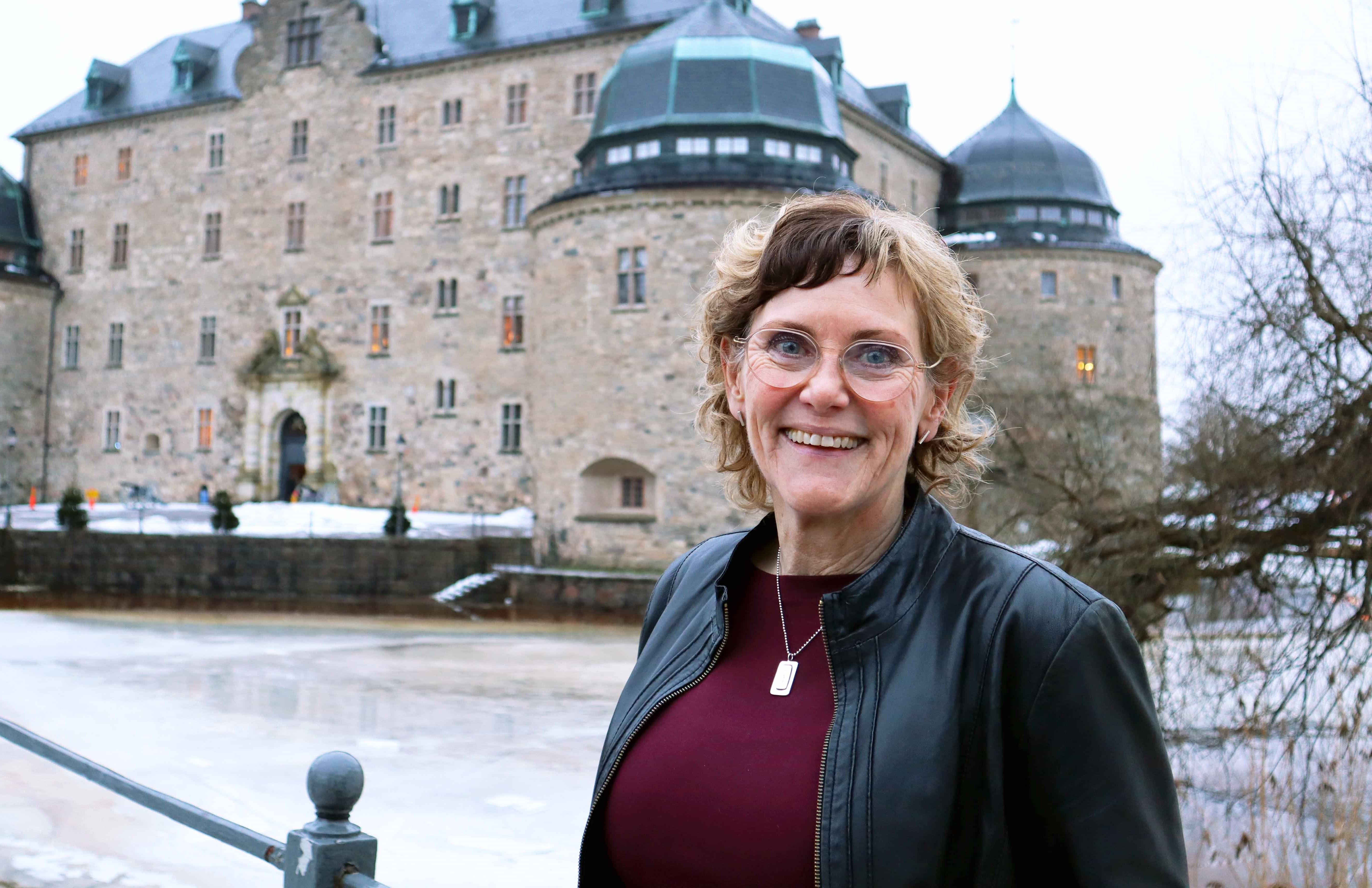 Katarina Hansson i svart skinnjacka framför Örebro slott. Foto: Emma Lado