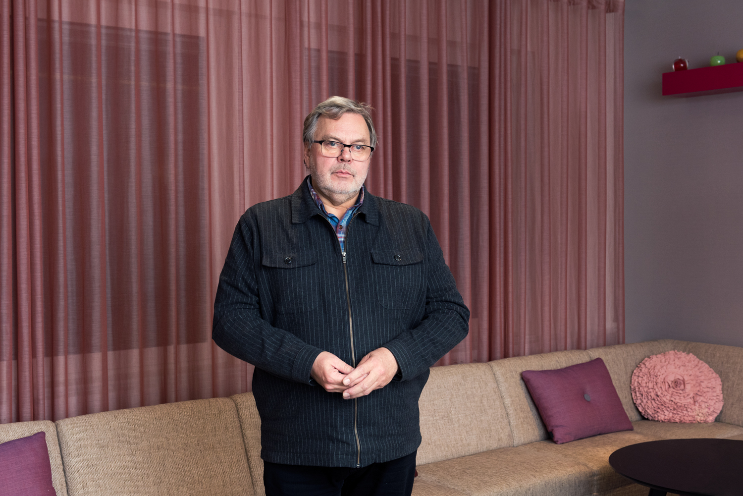 Mats Bernetstedt med rosa gardin i bakgrunden i Folkbildningsrådets lokaler.