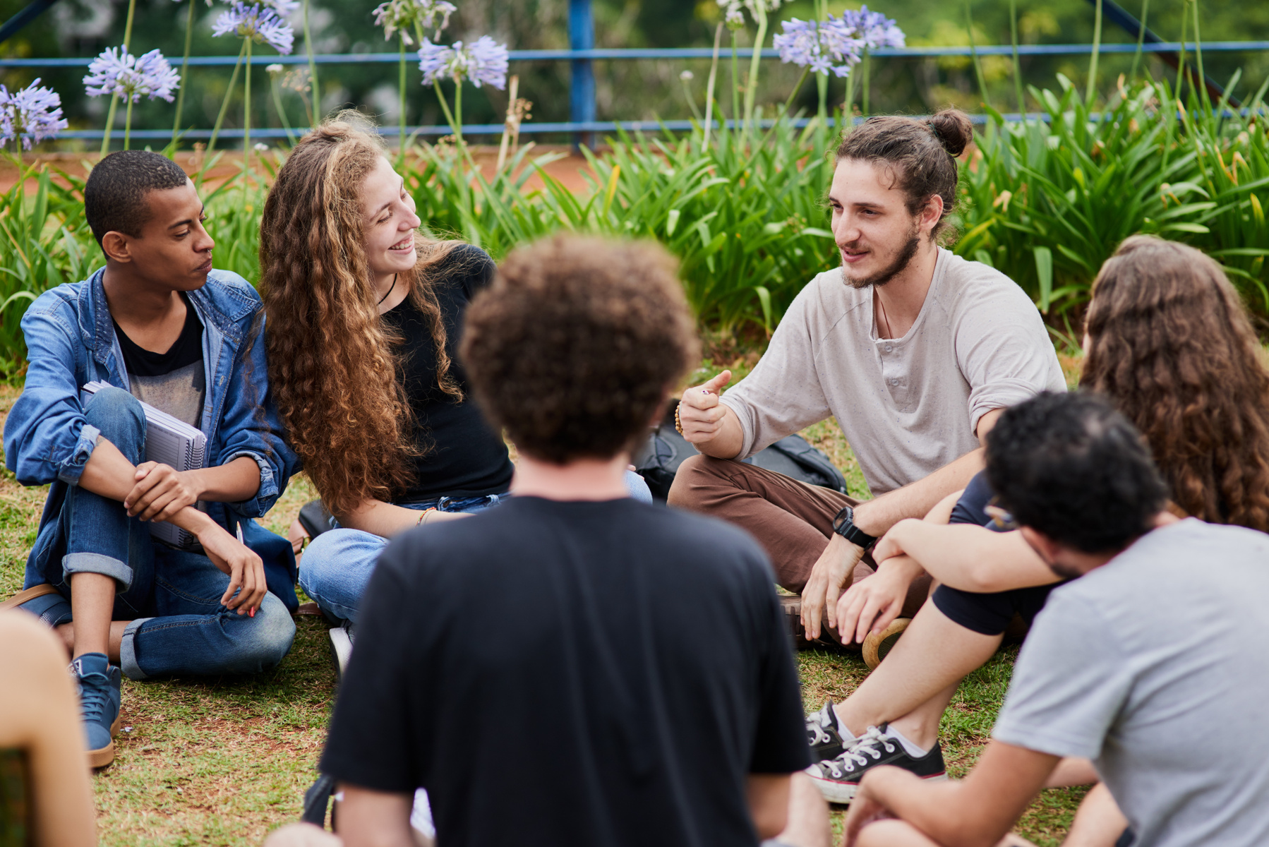 En grupp studenter som sitter tillsammans utomhus och studerar.