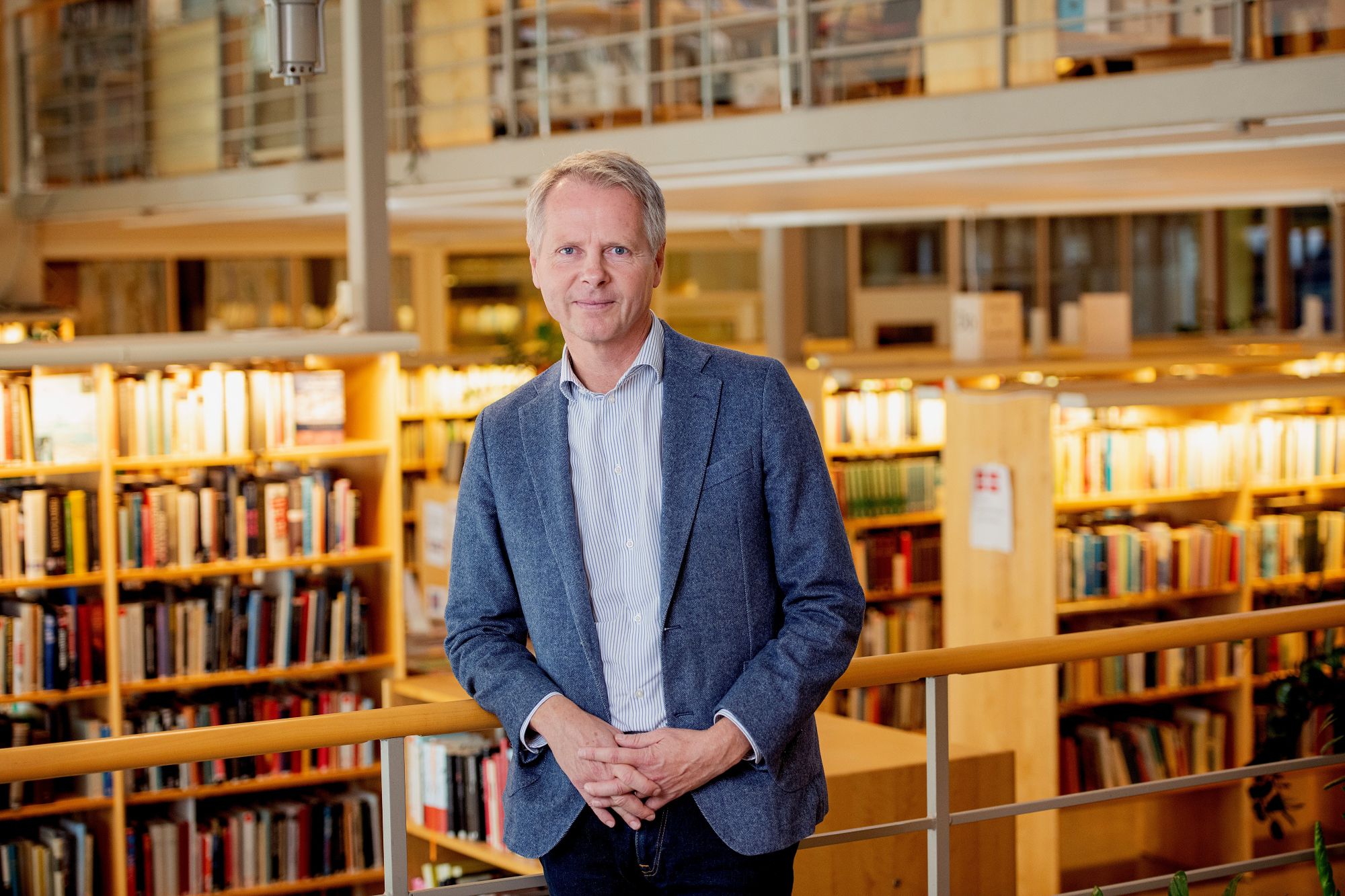 Christer Nylander står i ett bibliotek.