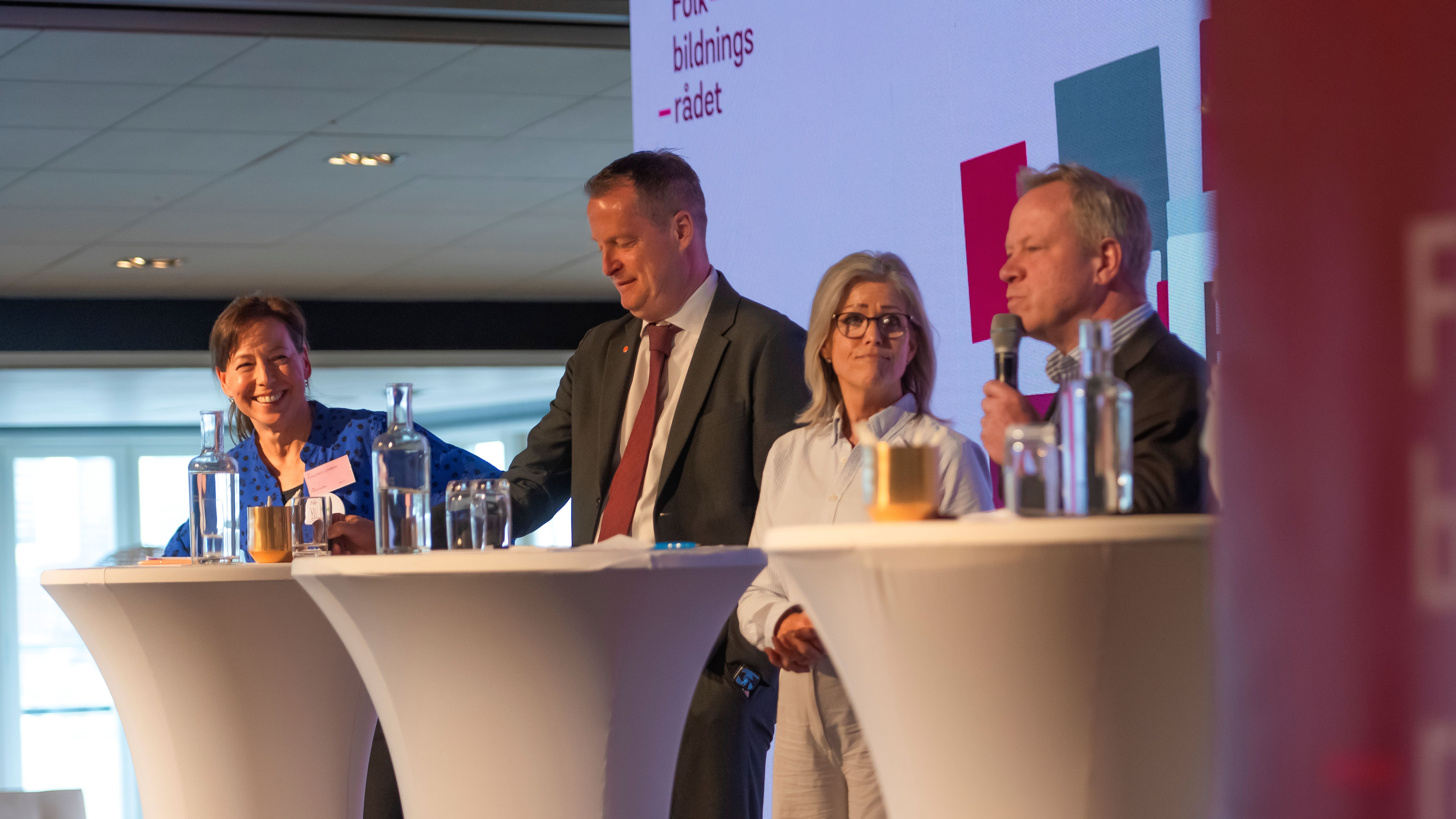 Anna-Karin tillsammans med resten av panelen på scen på konferensen. Anna-Karin ser glad ut medan statssekreteraren pratar.