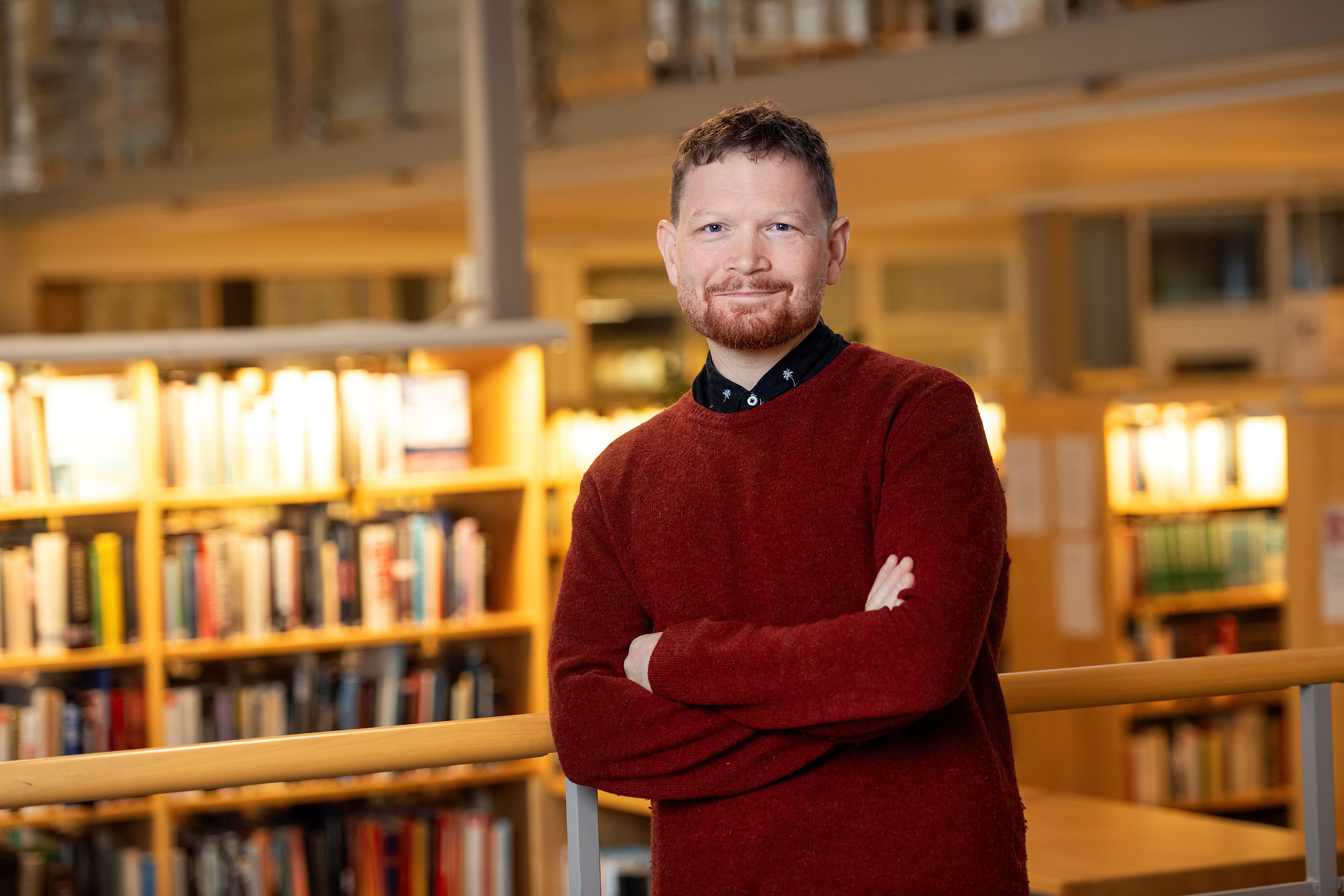 Folkbildningsrådets presskommunikatör Thor Rutgersson. Thor har en mörkblå kavaj på sig, han står halvlutad mot ett vit skåp och tittar rakt in i kameran.