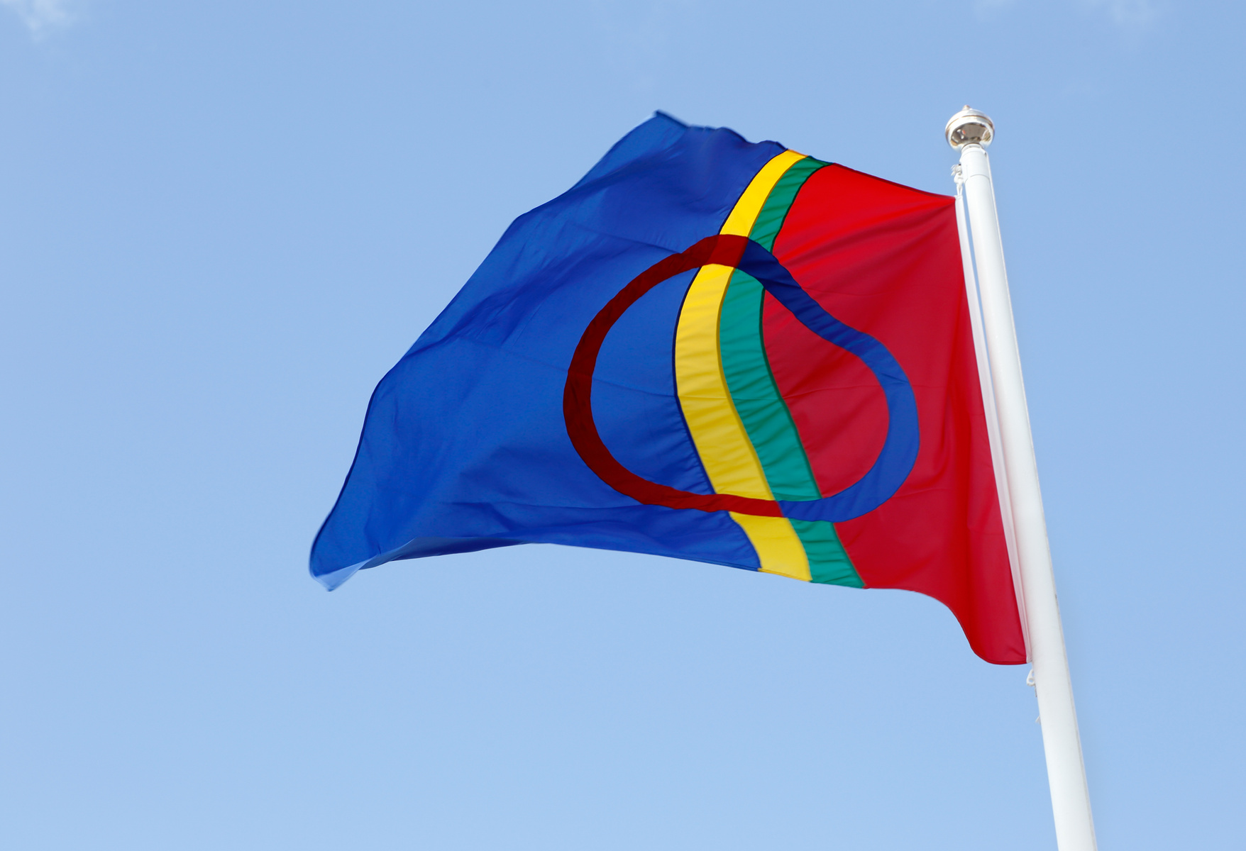Den samiska flaggan som vajar mot en blå himmel.